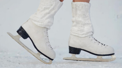 legs in white skates in ice rink