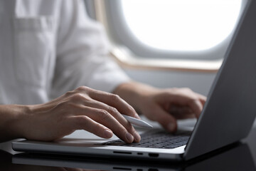 businessman working on a laptop on an airplane