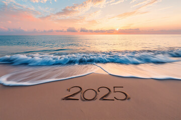 The year 2025 etched in the sand with waves washing ashore at sunset.