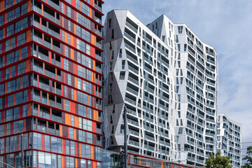 This image depicts modern high-rise buildings with striking red and white geometric patterns, highlighting contemporary urban architecture and the innovative design in residential areas  in Rotterdam