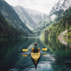 A man kayaks on a quiet lake surrounded by picturesque mountains. Traveling in the wild.