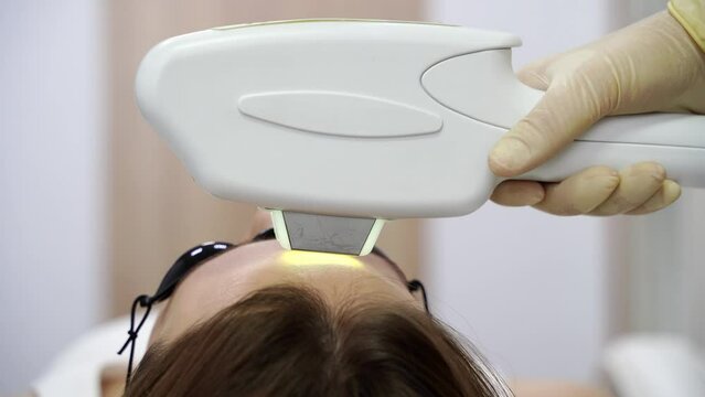 Face procedure. Professional dermatologist uses modern technology for laser hair removal. The lady undergoes a rejuvenating treatment, enhancing skin health in a well-equipped beauty clinic