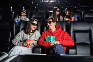 A group of friends who are laughing at the premiere of a comedy in the cinema. Entertainment and...