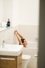 Obraz premium Dark-haired woman feeling relaxed in the bathroom