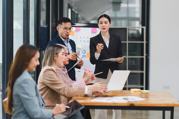 Professional diverse business team presenting and discussing data charts and graphs during meeting in modern office.