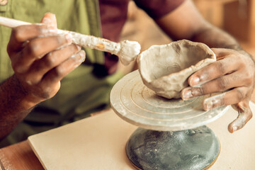 Male sculptor working on a new clay mug in his office