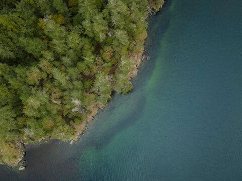 Aerial view of tranquil lake surrounded by untouched forest, Sooke, British Columbia, Canada.