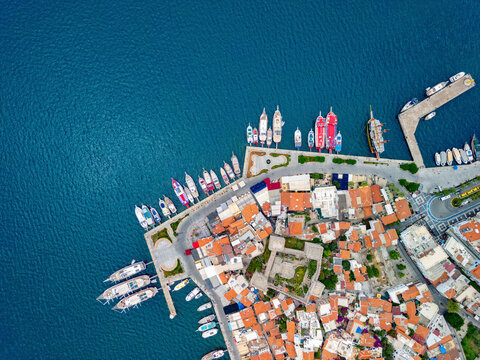 Aerial view of vibrant marina with boats and rooftops along the coastline, Marmaris, Turkey.