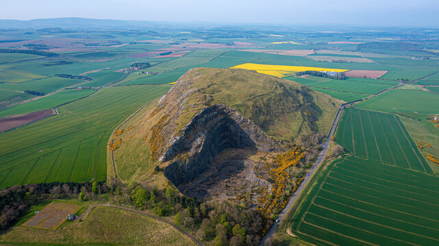 Aerial view of Traprain Law with fields and rock formation, Haddington, Scotland.