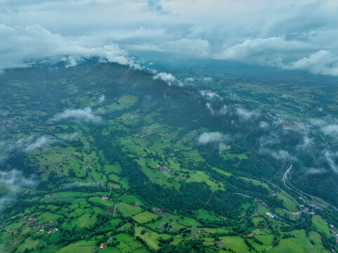 Aerial view of lush green valley with rolling hills and forest, Infiesto, Asturia, Spain.