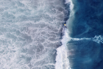Aerial view of surfers in the turquoise ocean waves, Cape Town, South Africa.