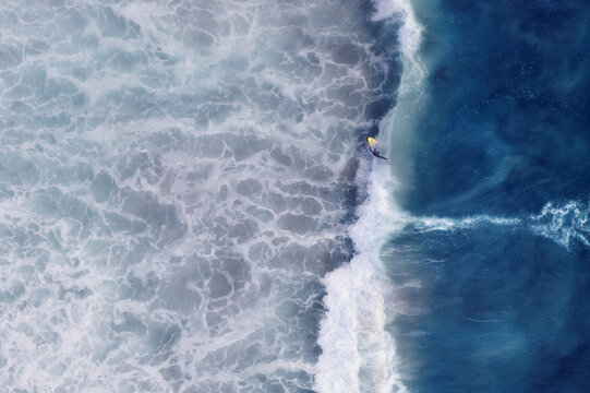 Aerial view of surfers in the turquoise ocean waves, Cape Town, South Africa.