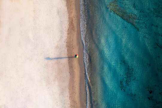 Aerial view of tranquil beach with turquoise water and person enjoying solitude, Port Willunga, South Australia, Australia.