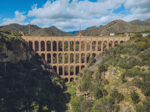 Aerial view of El Acueducto del Aguila, mountains, valley, sky, and clouds, Nerja, Malaga, Spain.
