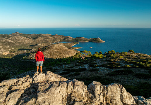 Aerial view of rocky coastline and island with hiker enjoying panoramic view, Lastovo, Croatia.