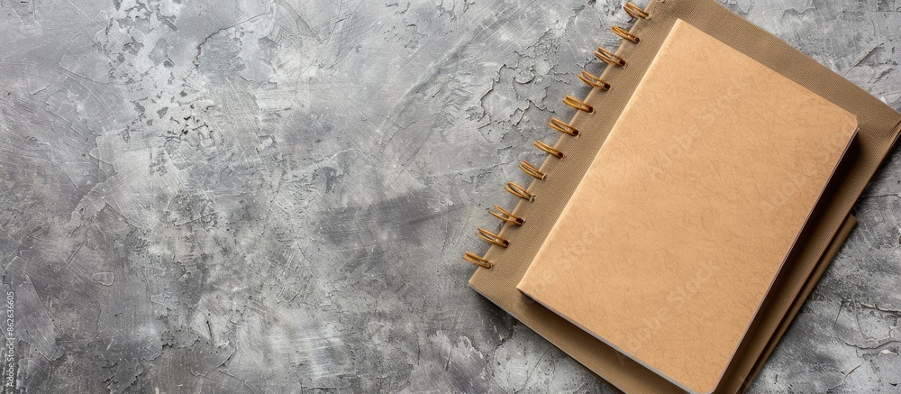 Leinwandbilder Top view of a brown kraft paper notebook placed on a gray concrete surface with ample copy space for additional images.