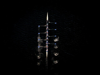 Aerial view of synchronized rowing team on dark water, Boston, Massachusetts, United States.