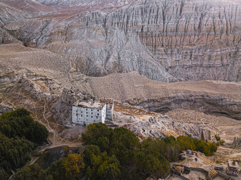Aerial view of remote monastery nestled in rugged mountain valley, Charang, Nepal.