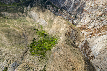 Aerial view of rugged, rocky terrain with terraced fields in Dho village, Bhijer, Karnali Pradesh, Nepal.
