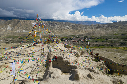 Aerial view of Himalayan mountain range with Buddhist flags and ancient Amepal's Dzong ruin, Lo Manthang, Gandaki, Nepal.