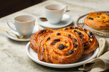 Table with french or continental breakfast with espresso coffee and croissant. Pain aux raisins,...