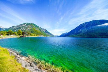 Fototapeta premium View of Lake Achensee in Tyrol. Nature at the turquoise lake and a mountain landscape in the background. Achental in Austria. 