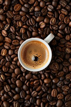 Espresso coffee mug over roasted coffee beans background