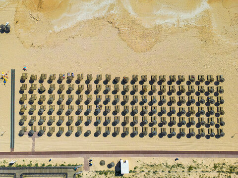 Aerial view of sunloungers and beach chairs on a sandy beach in Vilamoura, Faro, Portugal.