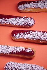 beautiful delicious eclair with coconut cream filling and raspberry jelly. confectionery, sweets....