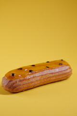 delicious beautiful vegan gluten free eclairs. mango passion fruit filling. yellow glaze and maracuja seeds. modern popular dessert. european pastry. tasty food