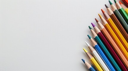 Fototapeta premium Top view of colored pencils on white background with copy space
