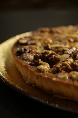 delicious tart with hazelnuts, almonds and caramel. pie with nuts. sweet pastry. close-up of a beautiful shiny cake