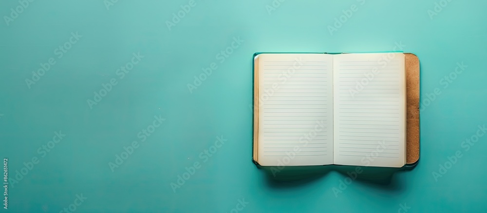 Poster colorful blank notebook on a green-blue backdrop with room for copy space image.