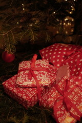 christmas and new year holidays. magical atmosphere. packaging and ribbons for gifts. beautiful boxes and things are packed in wrapping paper under the Christmas tree. christmas lights
