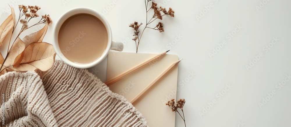 Poster workspace set on a white backdrop featuring a craft paper notebook, a pencil, and a coffee cup. perf