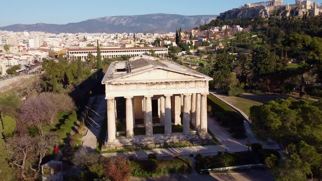 Temple of Hephaestus with the background of the city of Athens. Well-preserved artistic cultural heritage that attracts tourists in the summer period for a trip to discover the beauties of Greece.