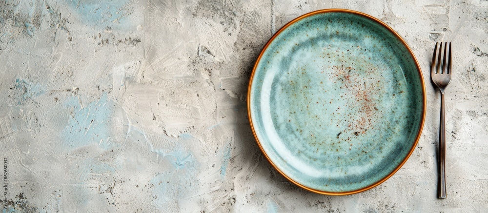 Aufkleber Top-down view of ceramic tableware including a plate with a fork on a plain background with space for text or other images. Copy space image. Place for adding text and design