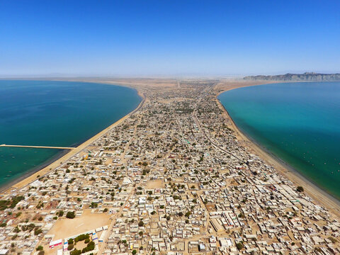 Aerial view of coastal cityscape with ocean and peninsula in Gwadar, Balochistan, Pakistan, Paddi Zirr Gulf.