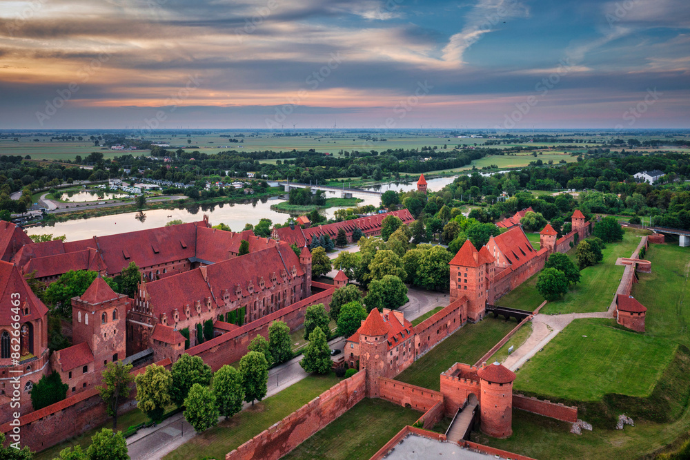 Wall mural Castle of theTeutonic Order in Malbork by the Nogat river at sunset.