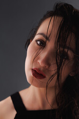 Portrait of asian woman with red lips and wet hair isolated on grey