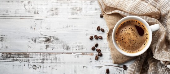 Start your day with an energizing breakfast featuring a cup of coffee placed next to coffee beans on a white wooden table, creating a relaxing ambiance with copy space image.