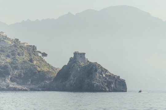 View of misty Amalfi Coast with Torre del Capo di Conca and serene sea, Campania, Italy.