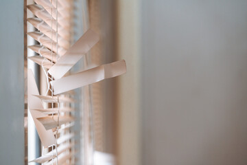 Close-ups of window blinds with a pull cord and partially broken blinds creating interesting light and shadow patterns.