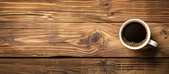 Top view of a coffee cup on a wooden surface with empty space for an image. Copy space image. Place for adding text and design