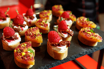 A gourmet selection of bruschetta appetizers topped with fresh strawberries, cheese, and sun-dried tomato