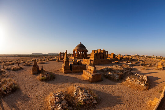View of ancient temple ruins with dome and brick structures in desert, makli, sindh, pakistan.