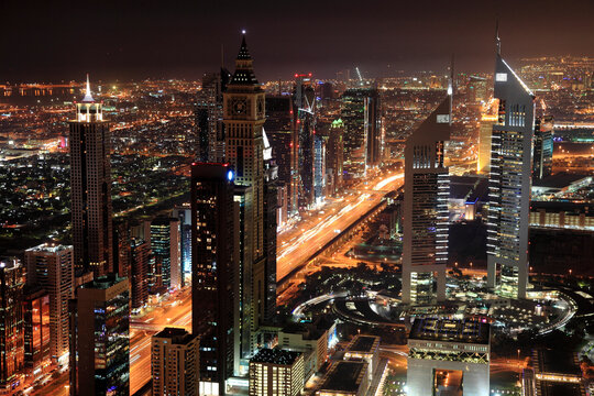 View of vibrant metropolitan cityscape with skyscrapers and illuminated lights, Dubai, United Arab Emirates.