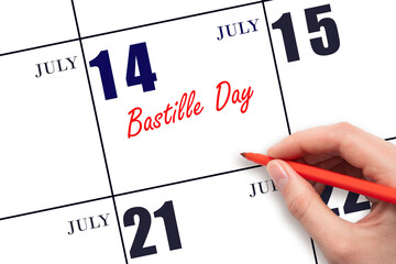 July 14. Hand writing text Bastille Day on calendar date. Save the date.