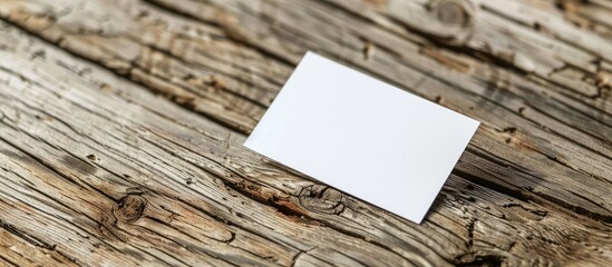 Close-up shot of a white business card on a wooden surface, suitable for branding, with available copy space image for customization.
