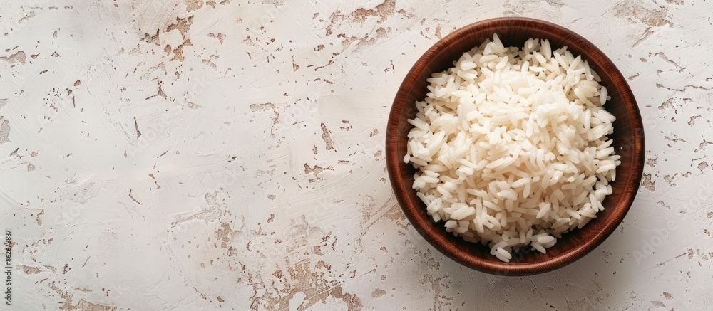 Poster top view of a bowl of boiled rice on a light background with ample copy space image.